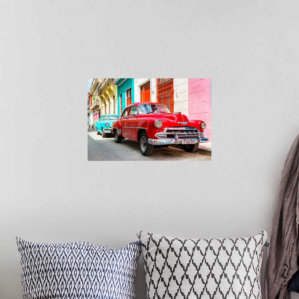 A bohemian room featuring Photograph of a turquoise and a red vintage Chevrolets parked along a colorful Havana street scene.