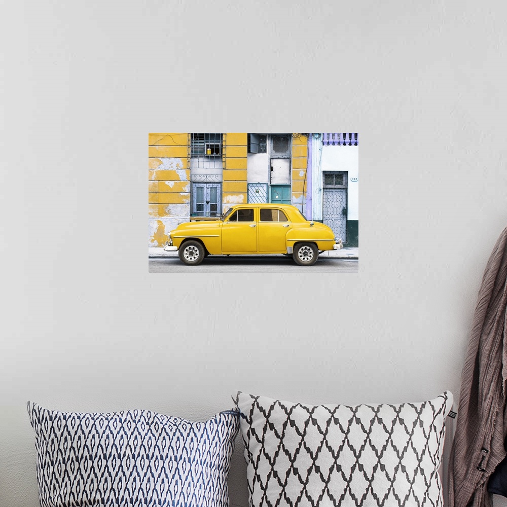 A bohemian room featuring Photograph of a yellow vintage car parked on the side of a street with an old building in the bac...