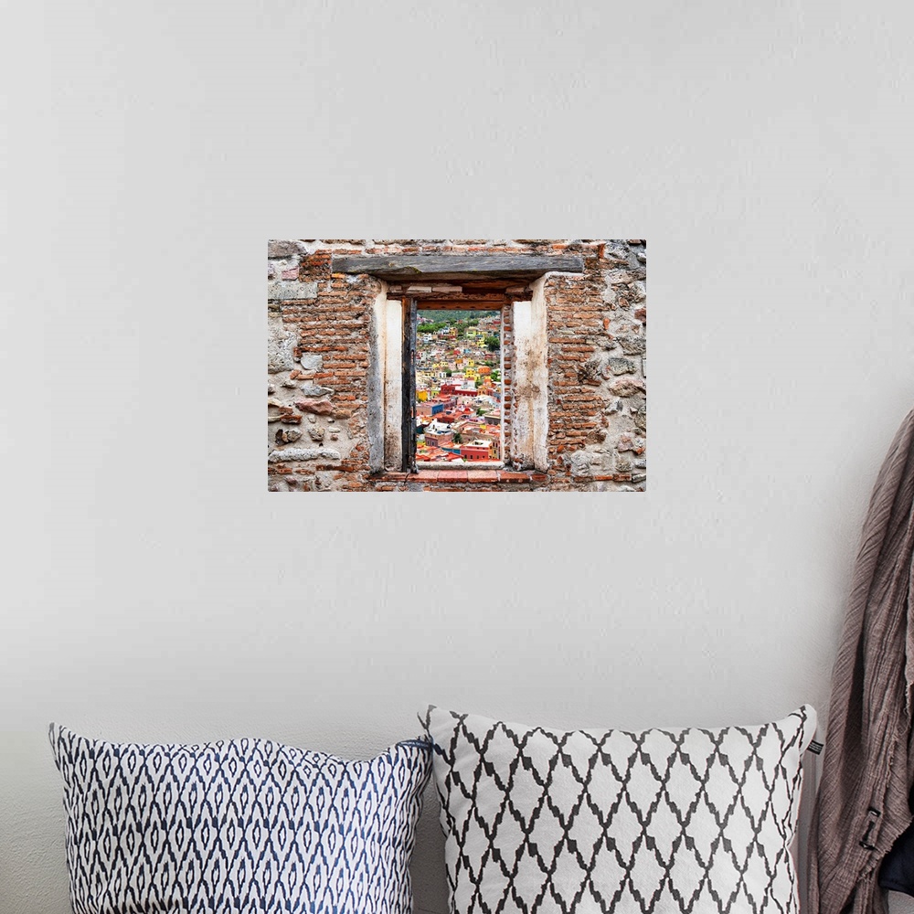 A bohemian room featuring View of the colorful city of Guanajuato framed through a stony, brick window. From the Viva Mexic...