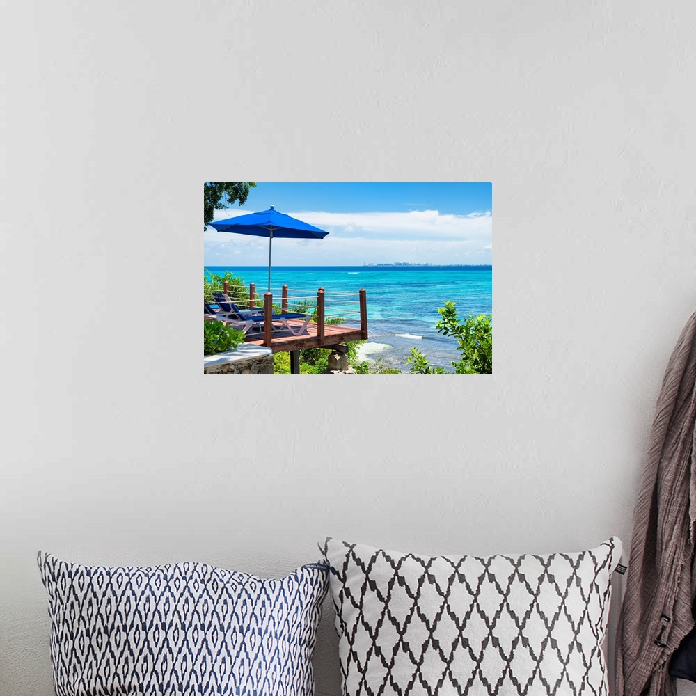 A bohemian room featuring Relaxing photograph of the clear Caribbean ocean with lounge chairs, an umbrella, and a city skyl...