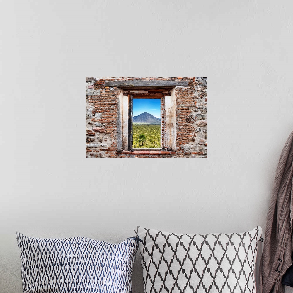 A bohemian room featuring View of the Mexican desert with a mountain in the background framed through a stony, brick window...