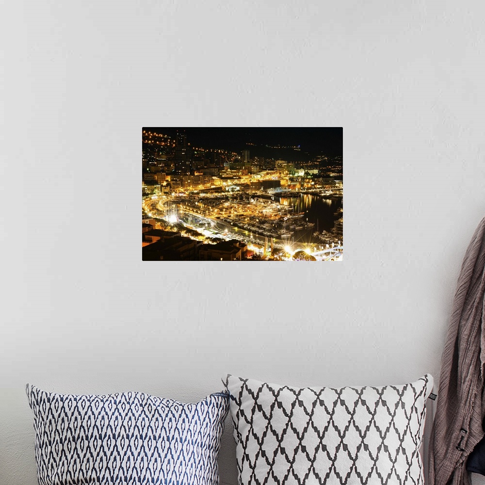 A bohemian room featuring The city of Monaco filled with bright lights in the evening.