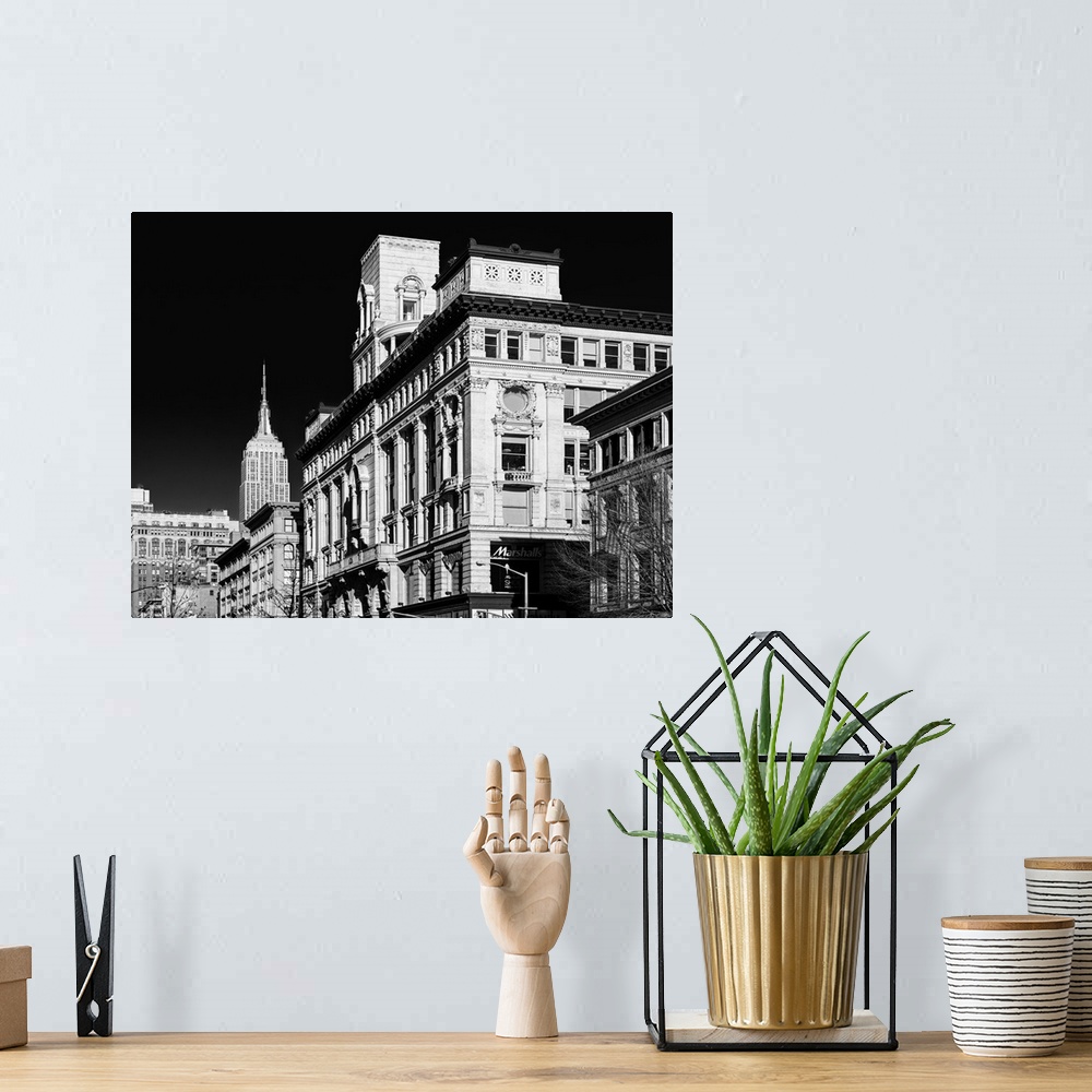 A bohemian room featuring A black and white photograph of the Empire state building standing tall in NYC.