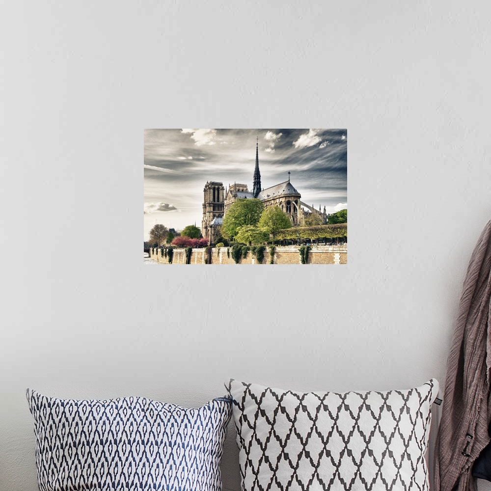 A bohemian room featuring Fine art photo of the Notre Dame Cathedral under a cloudy sky.