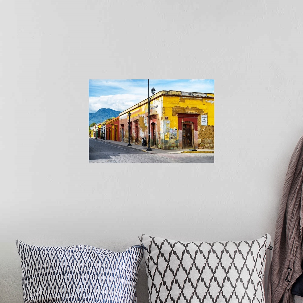 A bohemian room featuring Photograph of a bright city street in Oaxaca, Mexico, with a view of mountains in the background....