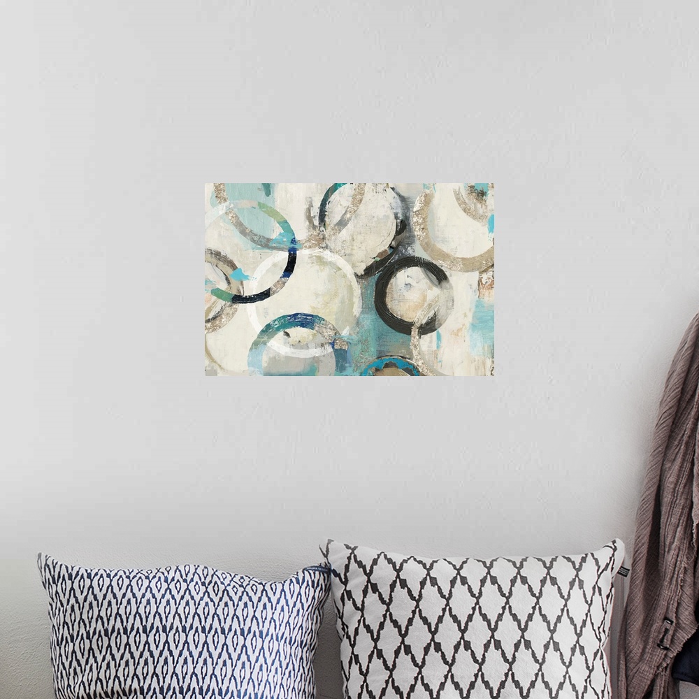 A bohemian room featuring Abstract artwork of overlapping rings in shades of white, cream, and teal.