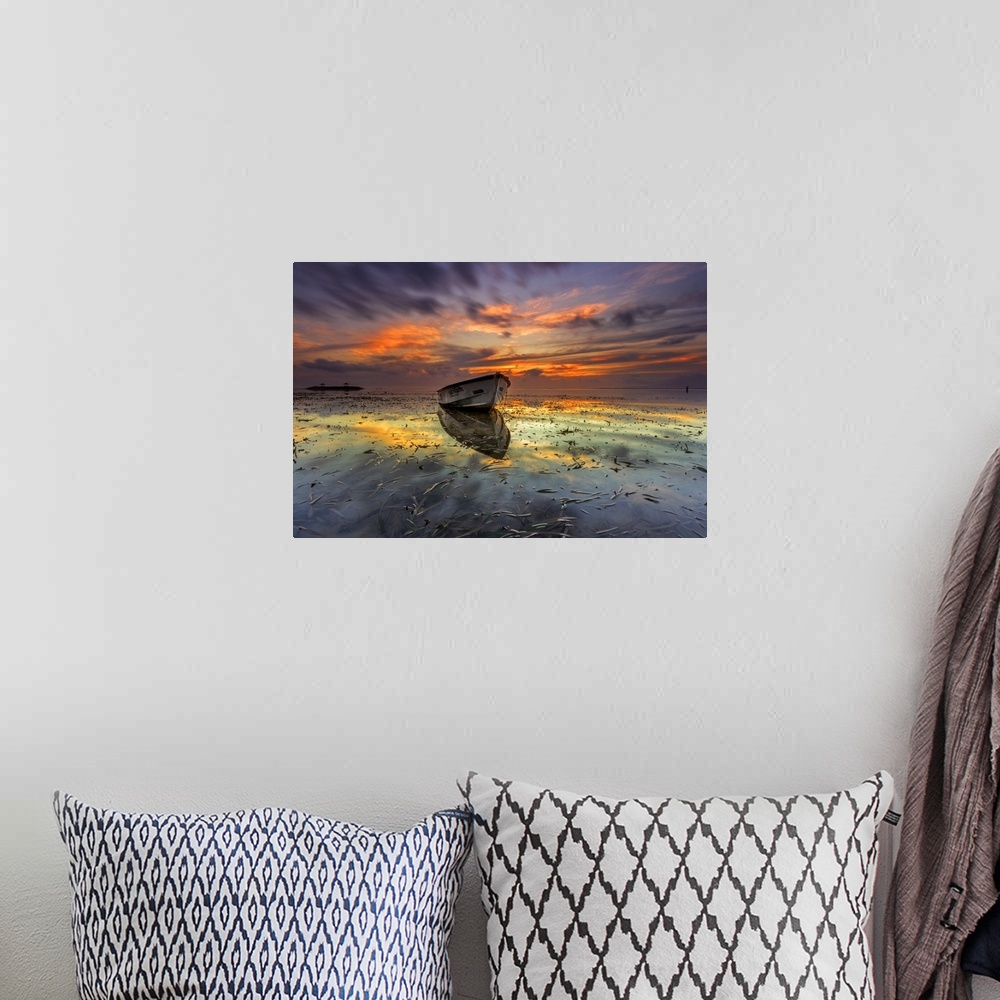 A bohemian room featuring Dramatic sunset over a seascape with a row boat in the foreground.