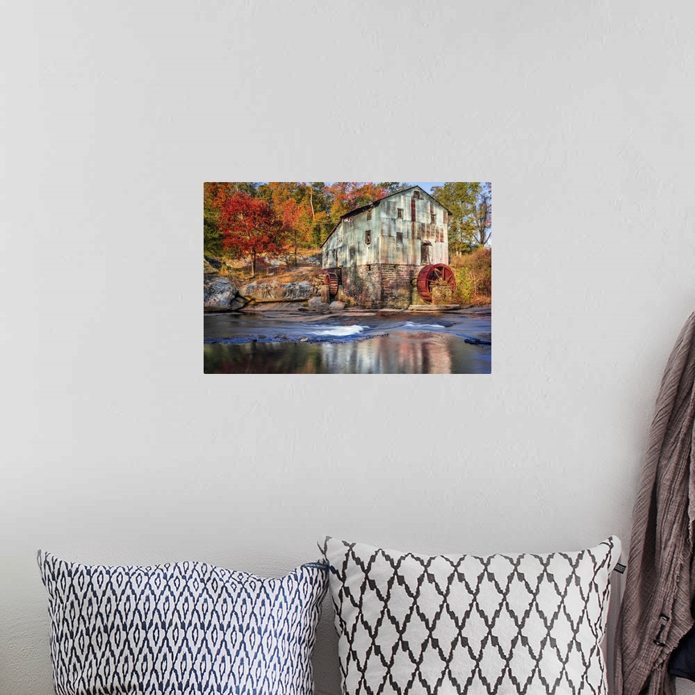 A bohemian room featuring Photograph of a watermill in forest with autumn foliage.