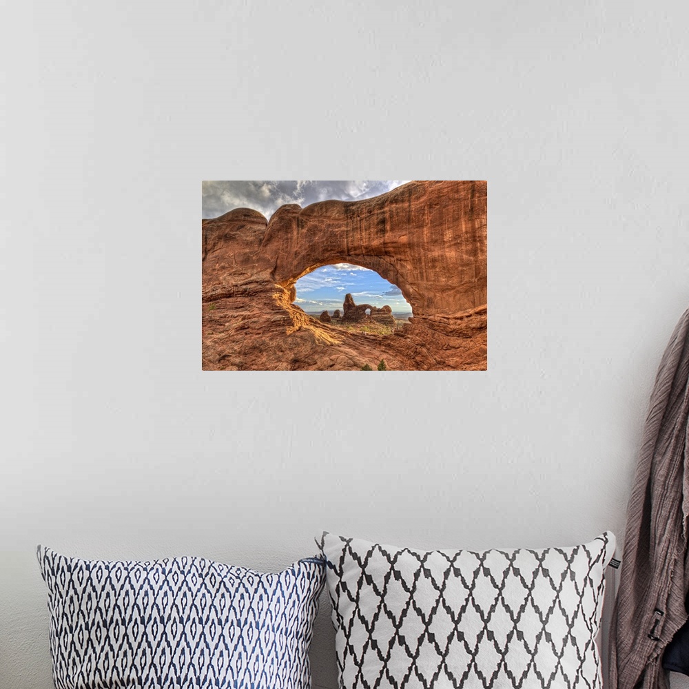 A bohemian room featuring Photograph of a large rock formation seen through a rock arch.