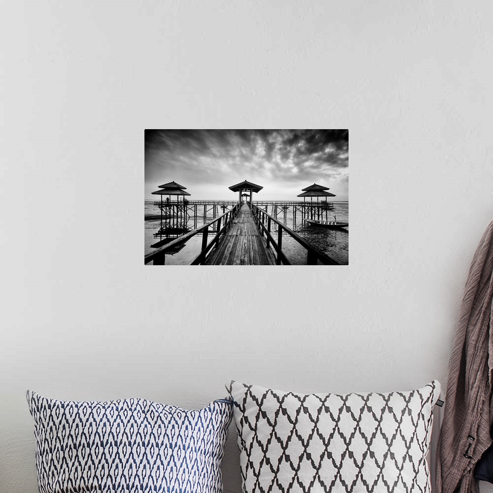 A bohemian room featuring Black and white photo of a wooden pier in Kenji Beach, East Java, Indonesia.