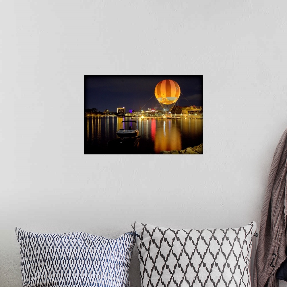 A bohemian room featuring A hot air balloon glowing against the night sky over a lake.
