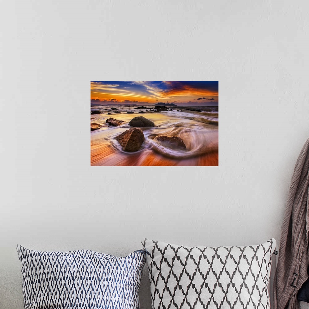 A bohemian room featuring Beautiful sunset over low tidewater rushing over rocks on the beach.