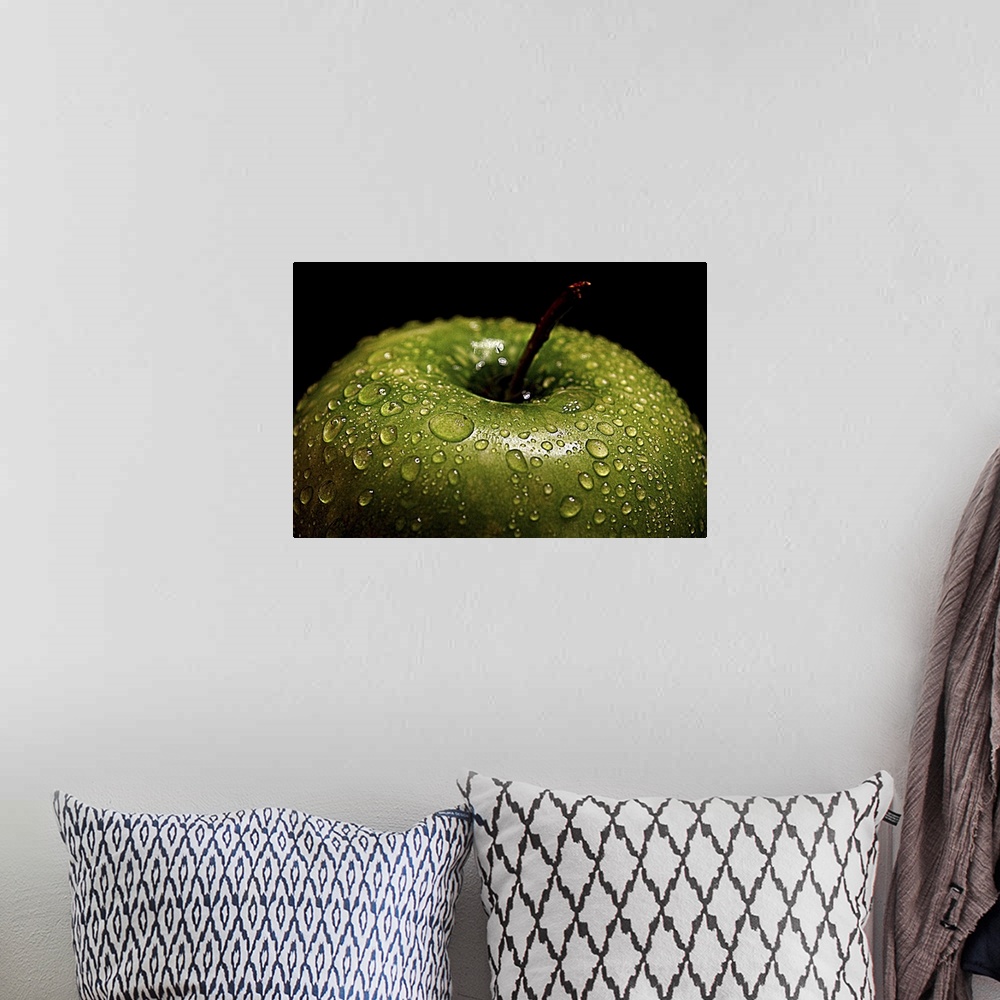 A bohemian room featuring A bright green apple covered in water droplets.