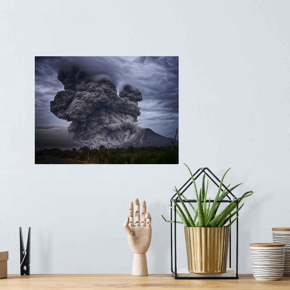 A bohemian room featuring Dramatic photograph of an intense plume of smoke rising from the mouth of a volcano in Indonesia.