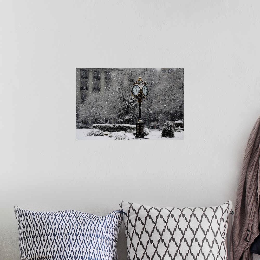 A bohemian room featuring A large clock standing in a park while snow falls around it.