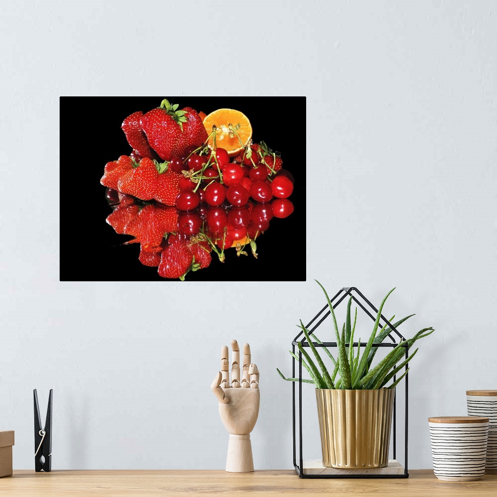 A bohemian room featuring A group of red fruits including strawberries, cherries, and a slice of orange, on a mirror.