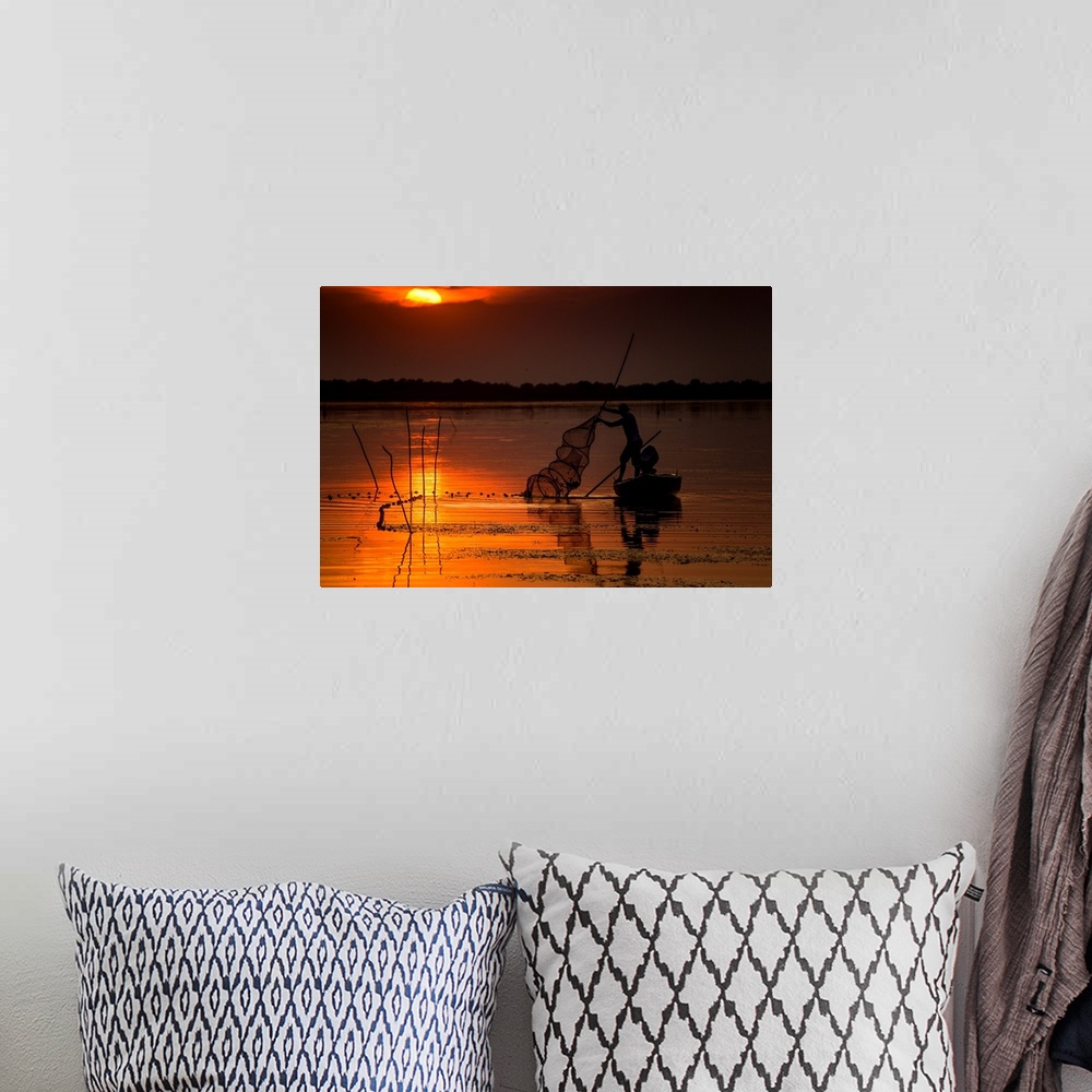 A bohemian room featuring A fisherman from Danube Delta, Romania at sunset.