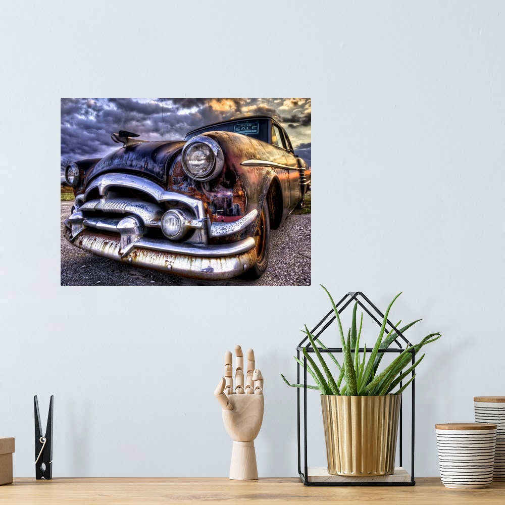 A bohemian room featuring An old, rusted '54 Packard car with sunset light.