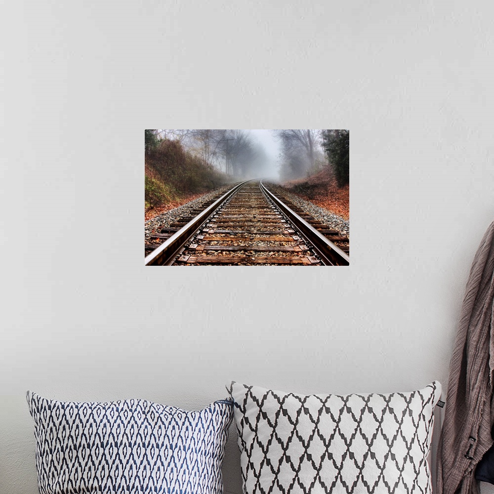 A bohemian room featuring Railroad tracks leading into the fog in the morning.