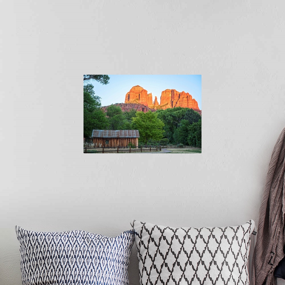A bohemian room featuring Landscape photograph of Cathedral Rock with a rustic wooden structure in the foreground.