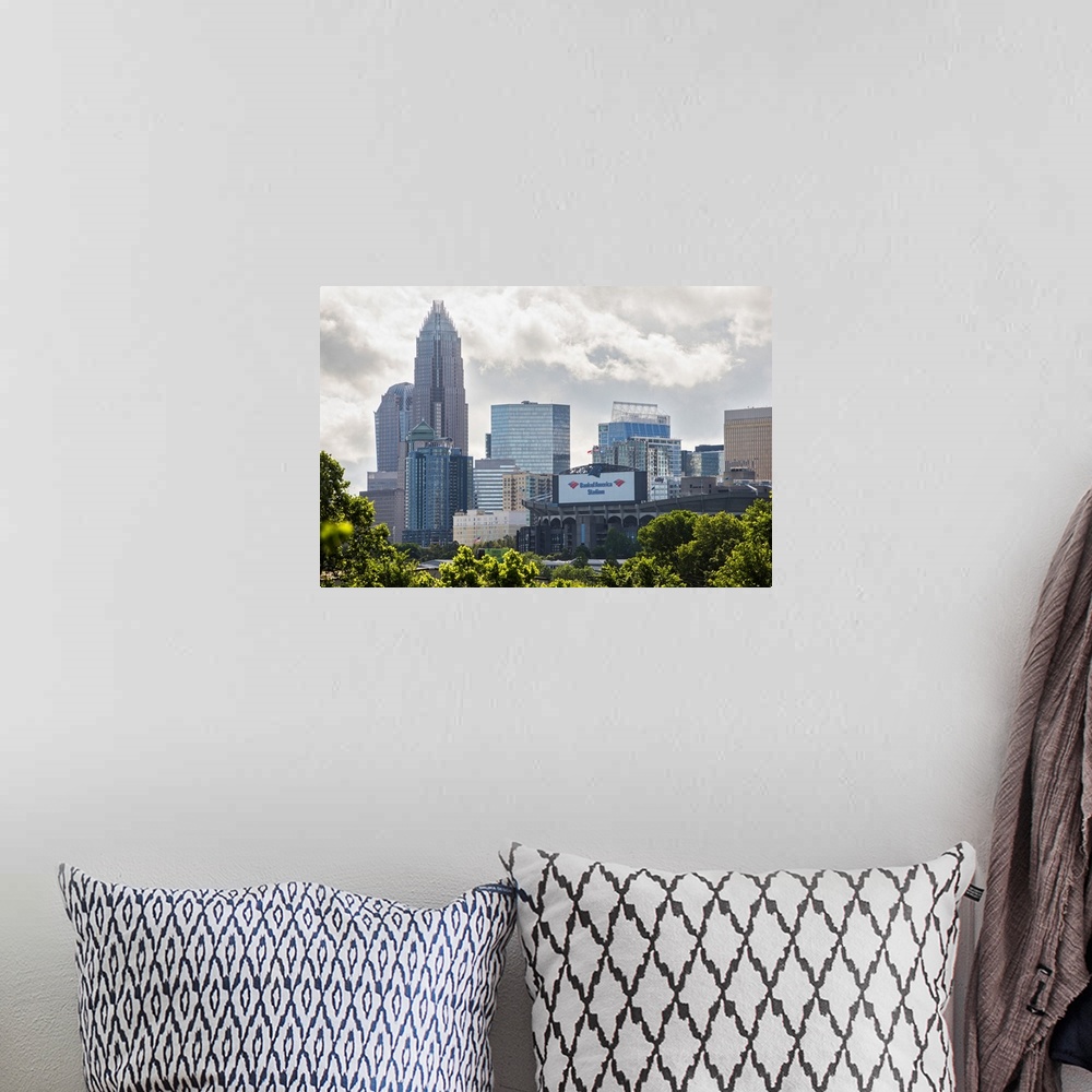 A bohemian room featuring A forest of trees in the foreground of the Charlotte North Carolina city skyline