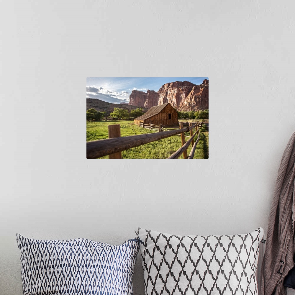 A bohemian room featuring Gifford Homestead with the cliffs of the Waterpocket Fold overlooking it at Capitol Reef National...