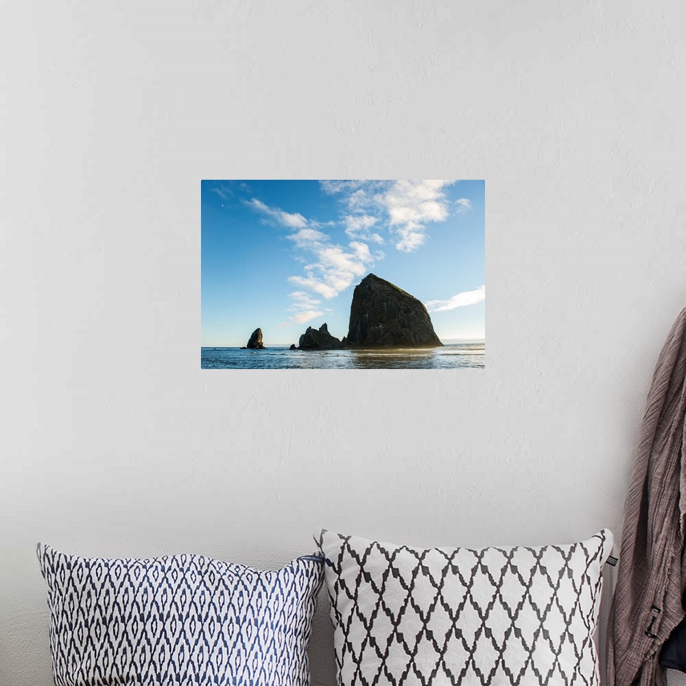 A bohemian room featuring Photograph of Haystack Rock with the golden sun shining on its side and the moon in the top corner.