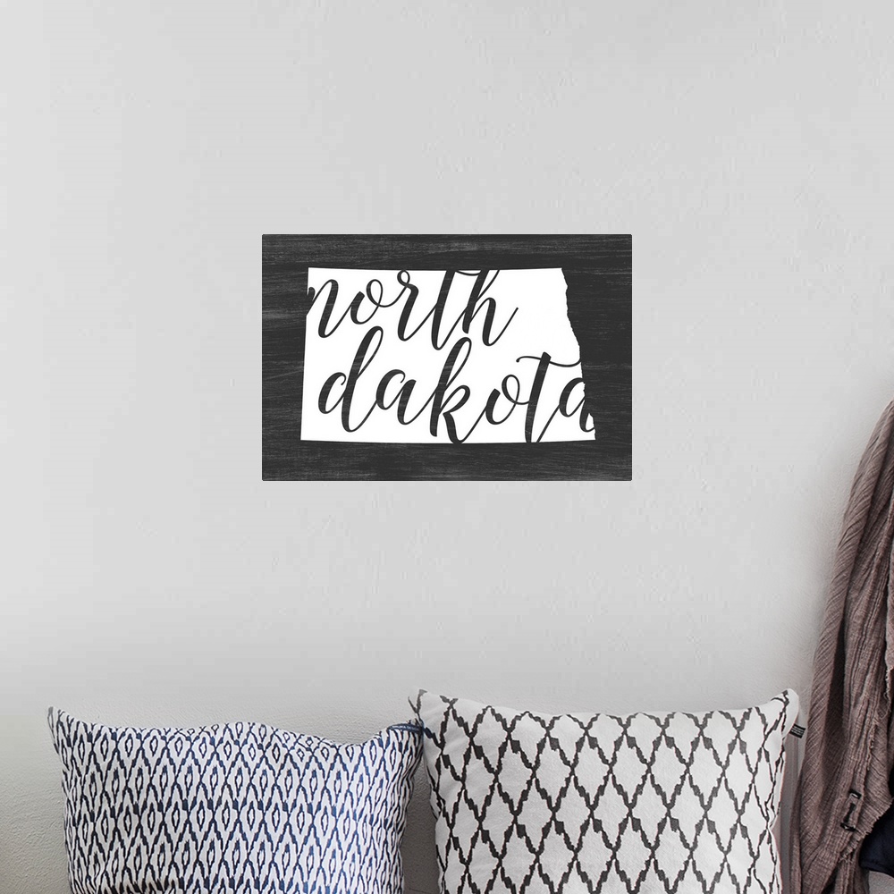 A bohemian room featuring North Dakota state outline typography artwork.