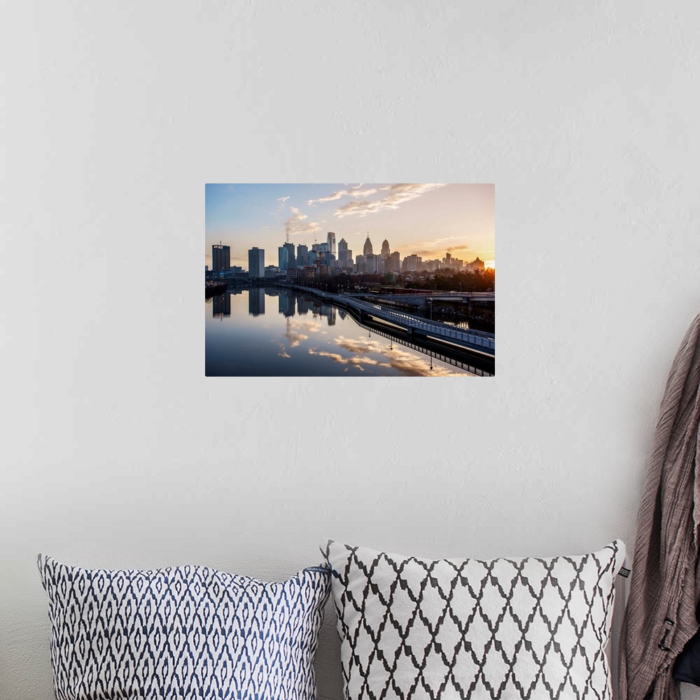 A bohemian room featuring The sun rises above Philadelphia's city skyline with the sky reflecting on the Delaware river.