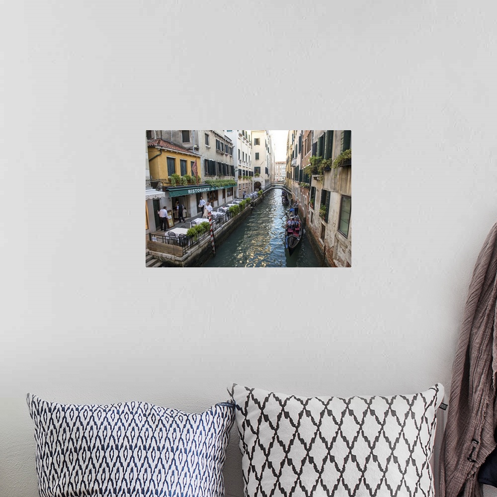 A bohemian room featuring Photograph of a canal in Venice with gondolas in a row, rowing by Ristorante Da Raffaele.