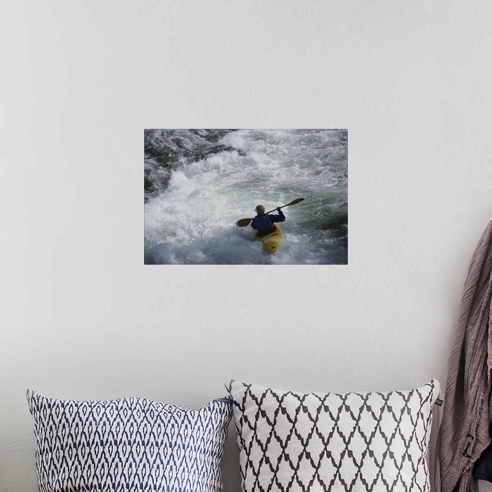 A bohemian room featuring A kayaker paddles through white-water rapids on the Snake River.