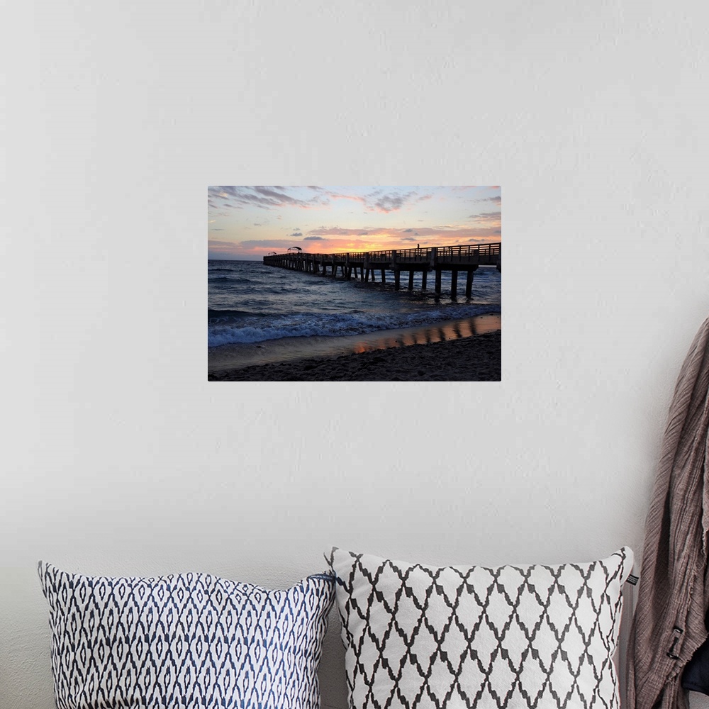 A bohemian room featuring The sun rises over an Atlantic Ocean pier.