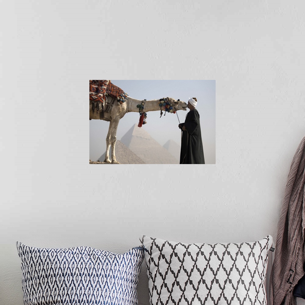 A bohemian room featuring A Bedouin guide with his camel, overlooking the Pyramids of Giza, Cairo, Egypt