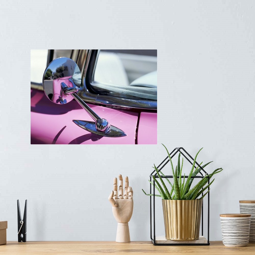 A bohemian room featuring Close-up of a wing mirror and reflection on a pink Cadillac car