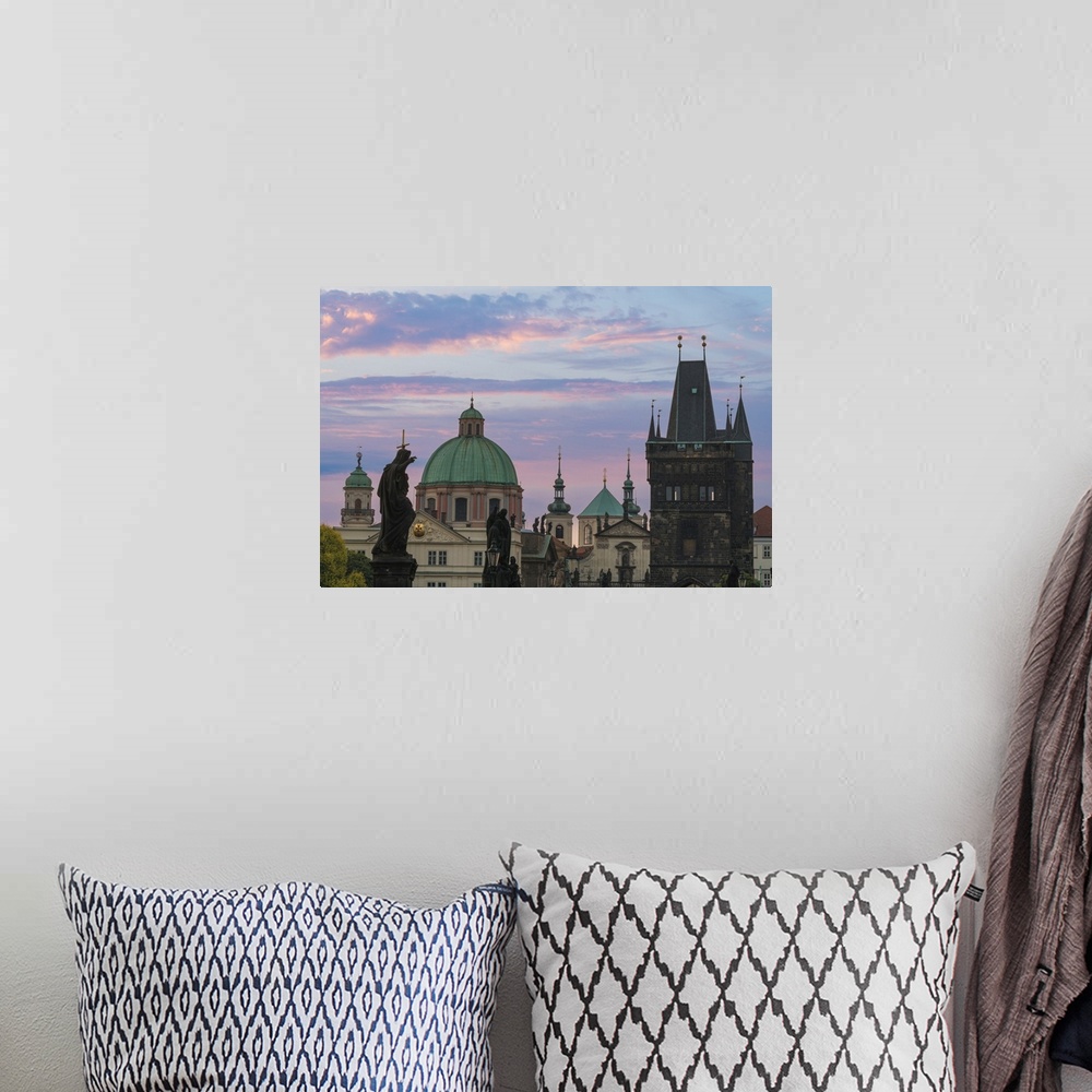 A bohemian room featuring Details of statues and spires at Charles Bridge at sunrise, featuring dome of Church of Saint Fra...