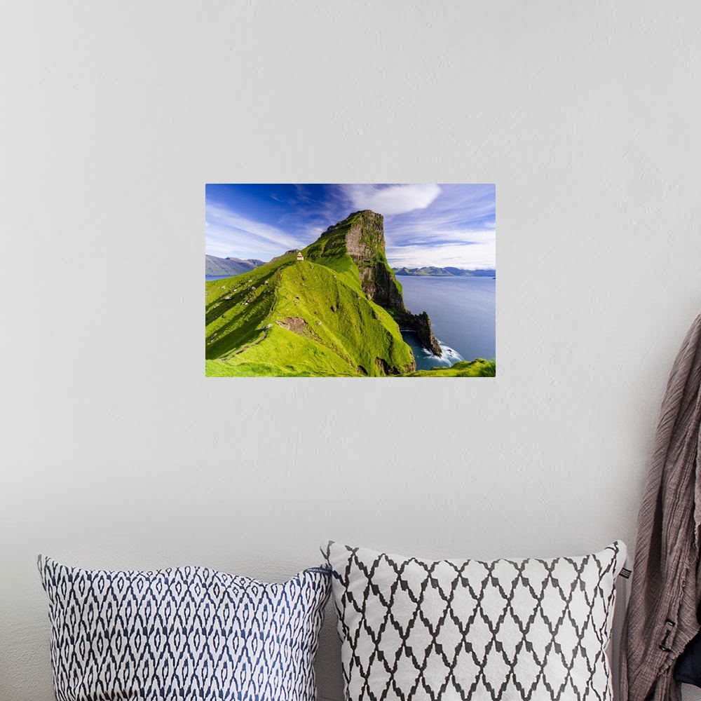 A bohemian room featuring Kallur lighthouse on cliffs covered with grass with Borgarin mountain peak on background, Kalsoy ...
