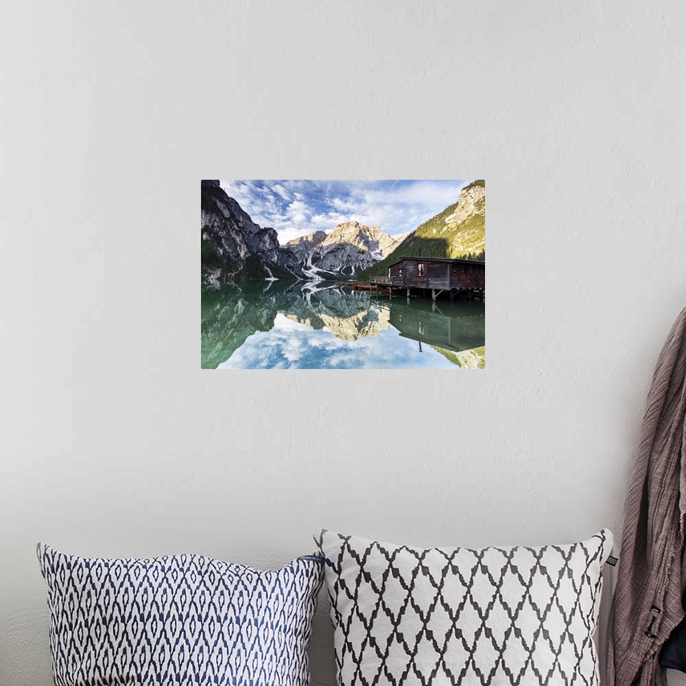 A bohemian room featuring Lake Braies (Pragser Wildsee) at sunrise with Croda del Becco mountain reflected in water, Dolomi...