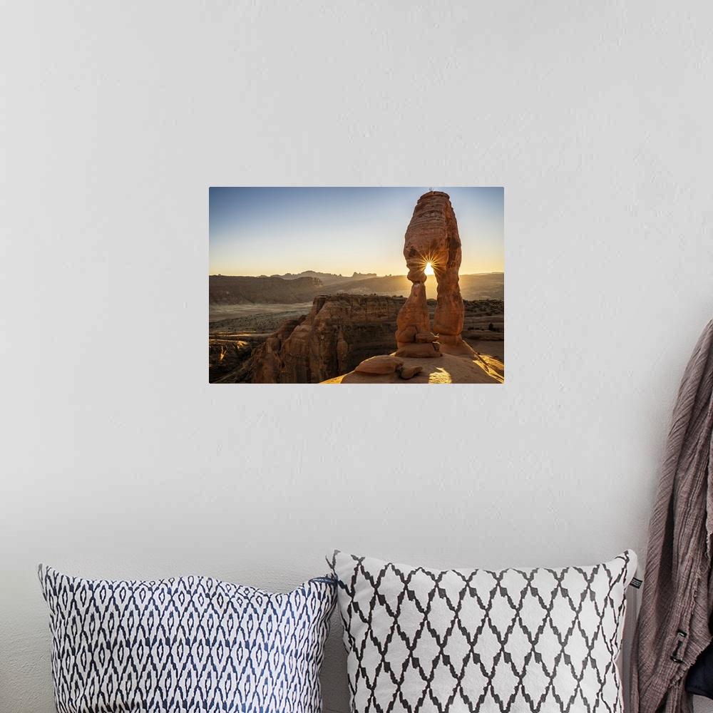 A bohemian room featuring Setting sun through Delicate Arch with sunburst, Arches National Park, Utah, United States of Ame...