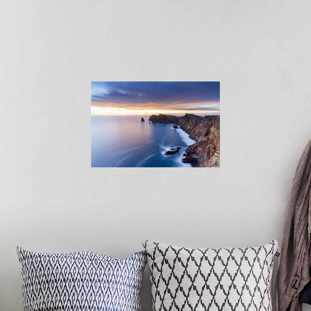 A bohemian room featuring Dramatic sky at dawn on cliffs washed by ocean from Ponta Do Rosto viewpoint, Sao Lourenco Penins...