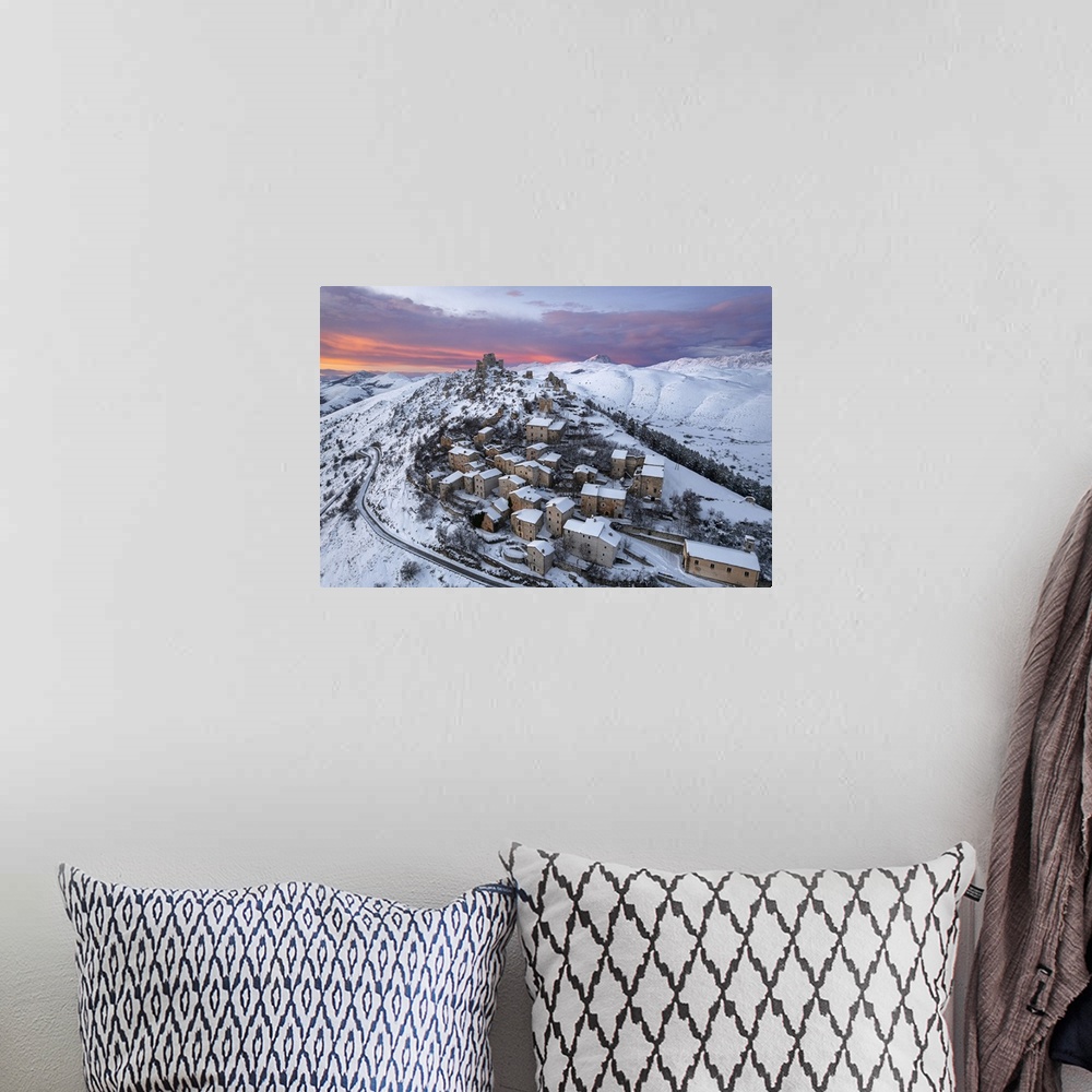 A bohemian room featuring Aerial winter view of the snow covered medieval village of Rocca Calascio with the castle and pin...