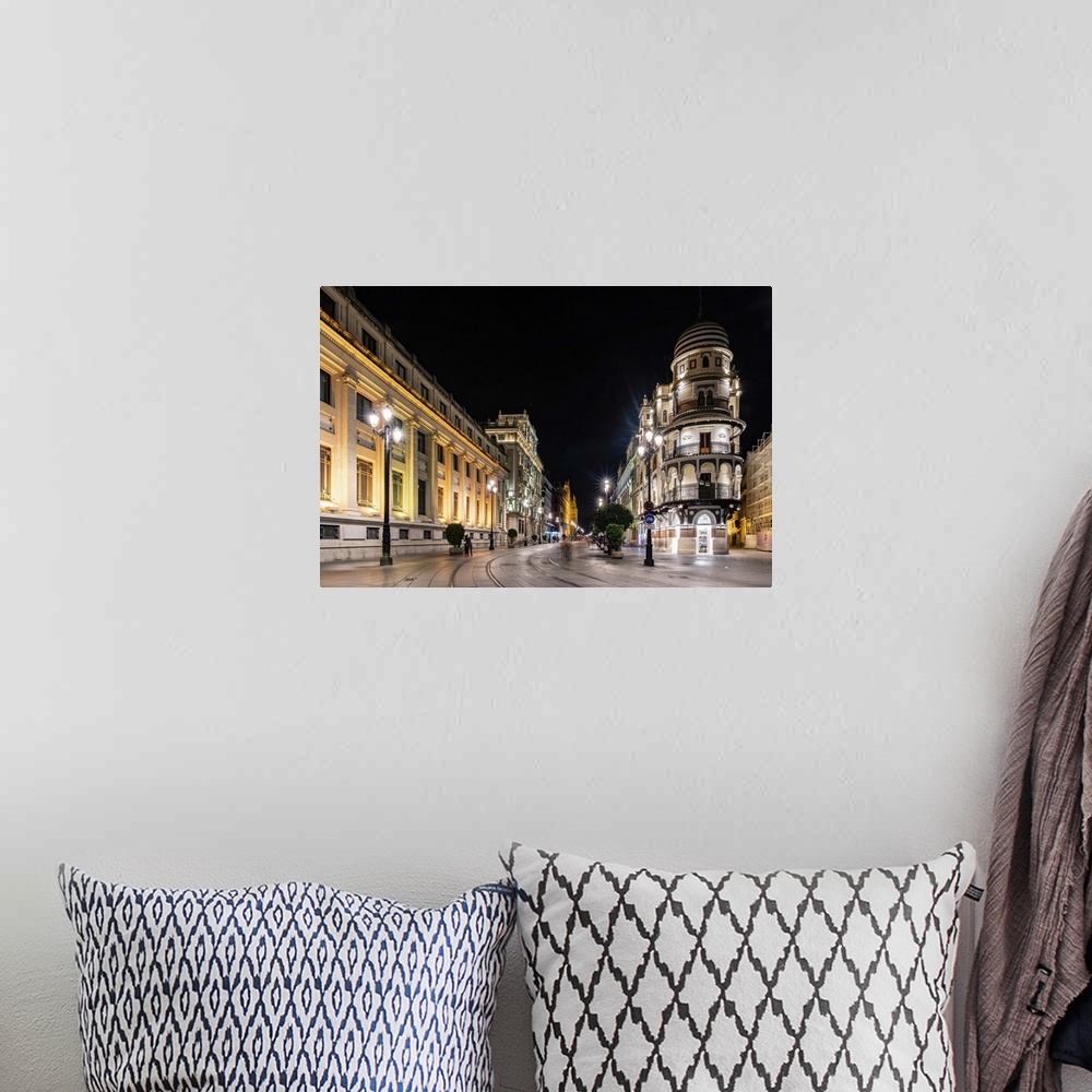 A bohemian room featuring The lights of Seville's buildings at night looking down the Avenida de la Constitucion towards th...