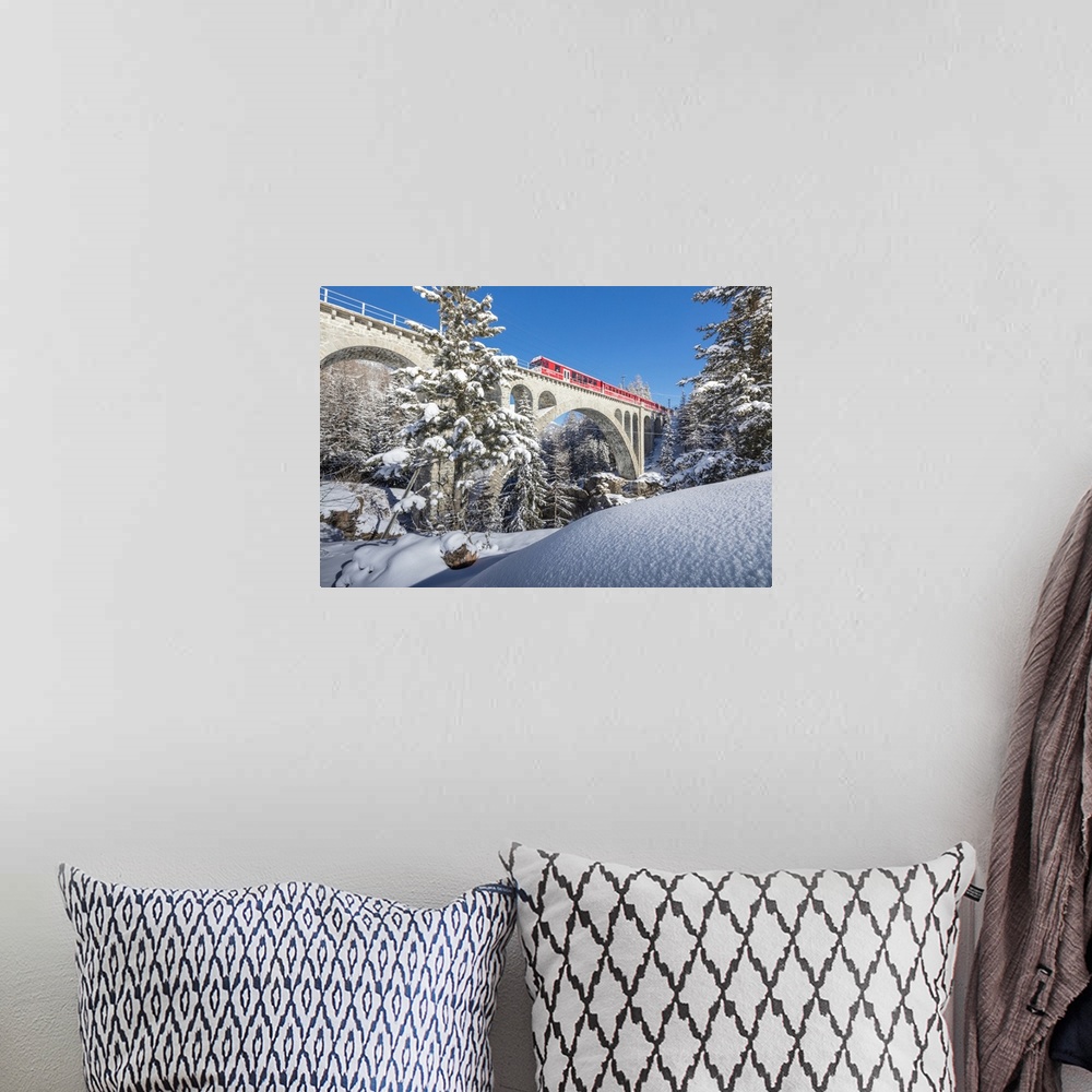 A bohemian room featuring The red train on viaduct surrounded by snowy woods, Cinuos-Chel, Canton of Graubunden, Engadine, ...