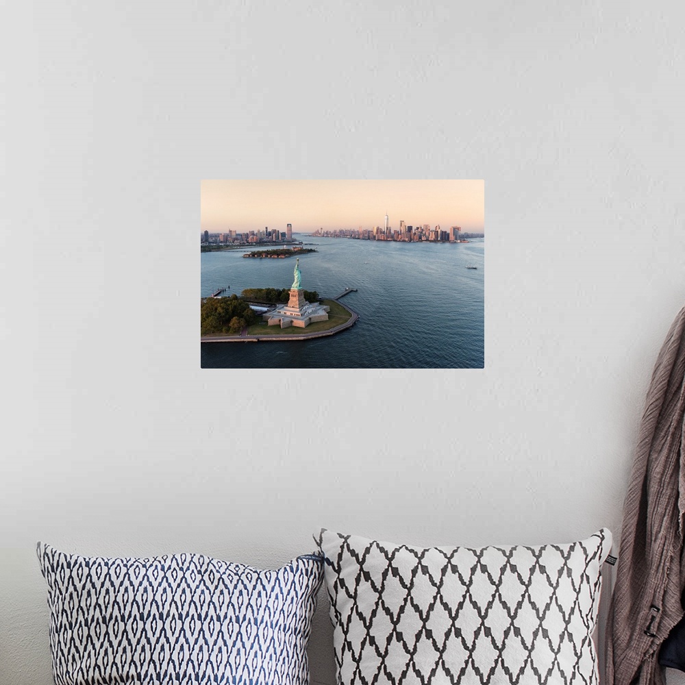 A bohemian room featuring Stature of Liberty and Manhattan from above at sunset