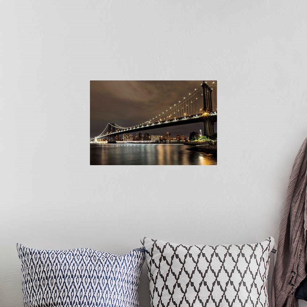 A bohemian room featuring The Manhattan Bridge in NYC after dark.