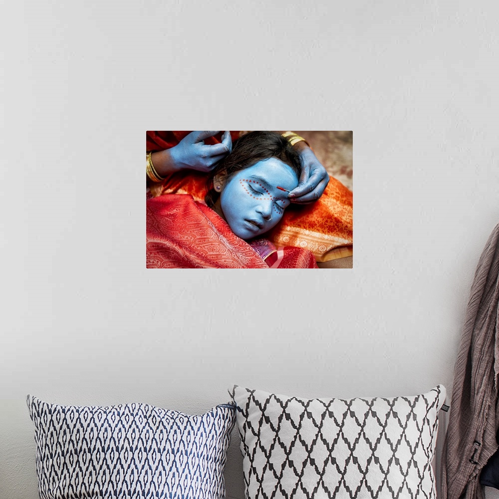 A bohemian room featuring Young girl having her face painted in Varinasi, India