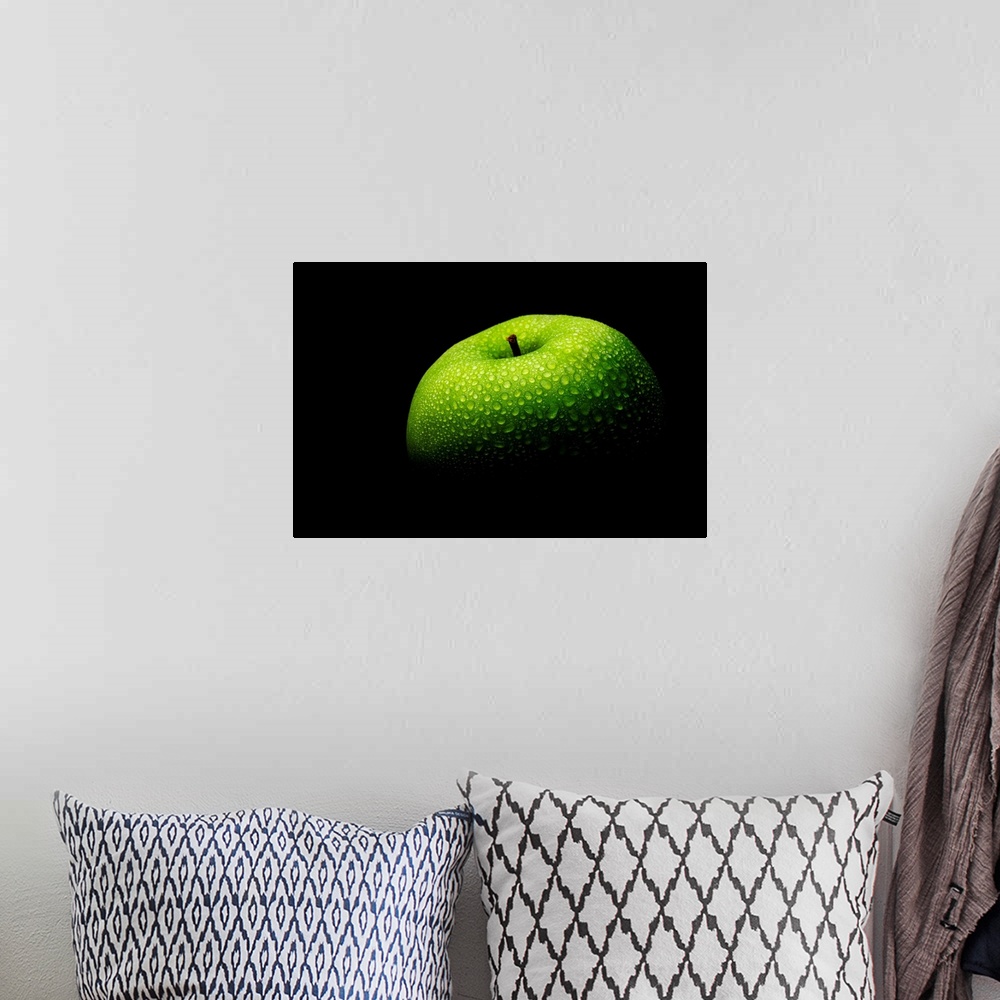 A bohemian room featuring A close up photograph of a fresh Granny Smith apple with waterdrops.