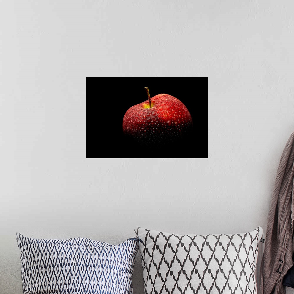 A bohemian room featuring A close up photograph of a fresh Red Delicious apple with waterdrops.