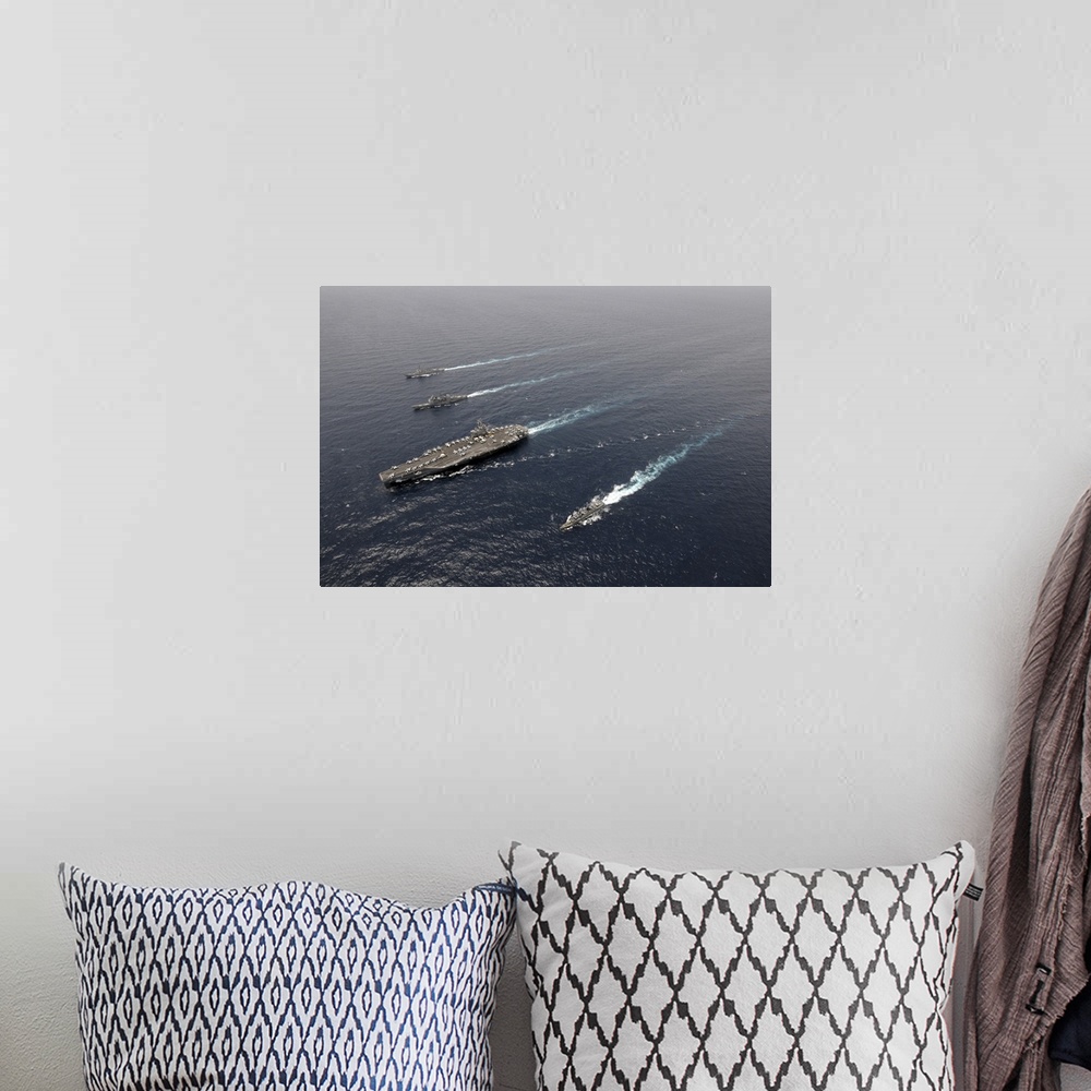 A bohemian room featuring A formation of ships traveling at sea.