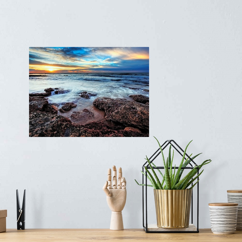 A bohemian room featuring Photograph taken of the ocean that rushes up onto rocks that are pictured in the foreground. The ...