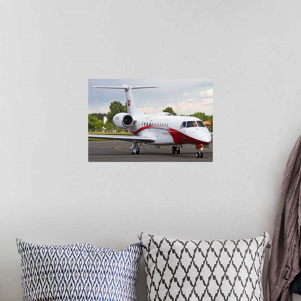 A bohemian room featuring An Embraer Legacy 600 private jet taxiing at Turin Airport, Italy.